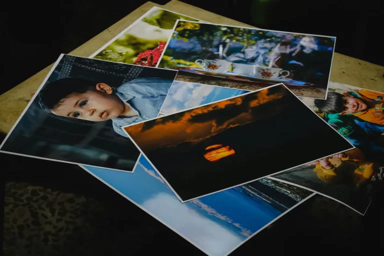 Choosing the right images from a spread of printed photographs laid out for selection.