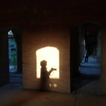 Photographer’s shadow framed by archways showing how photography composition decisions change the frame