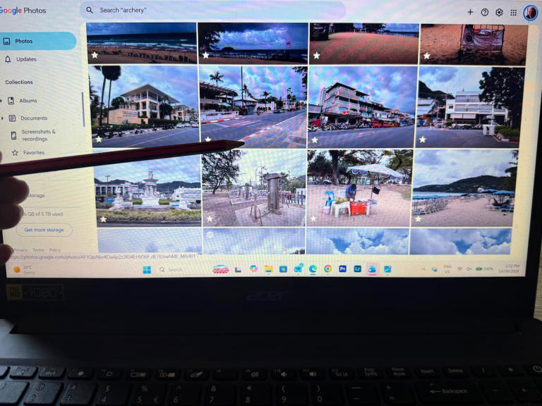Choosing travel guide images from a photo library on a laptop