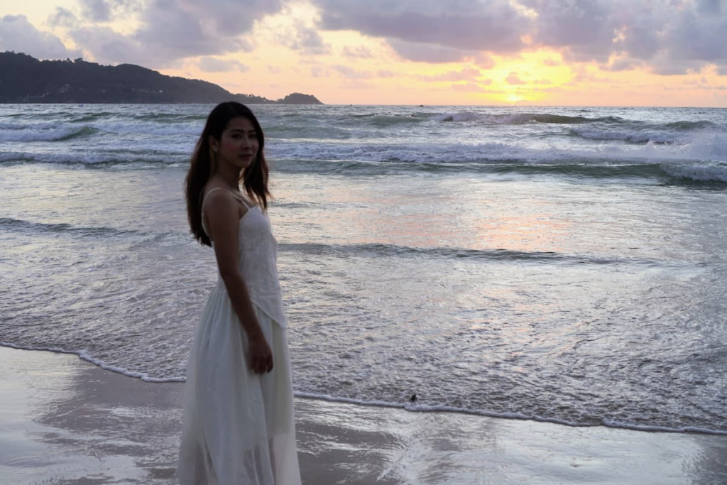 Sunset on Patong Beach with a person walking beside the sea